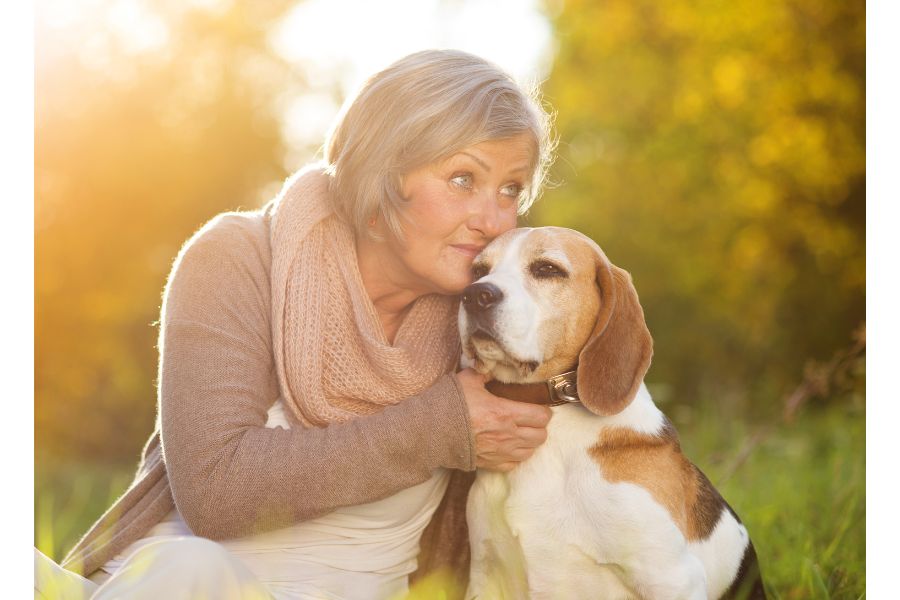 older lady hugging dogs with soft coat that uses skin and coat supplement